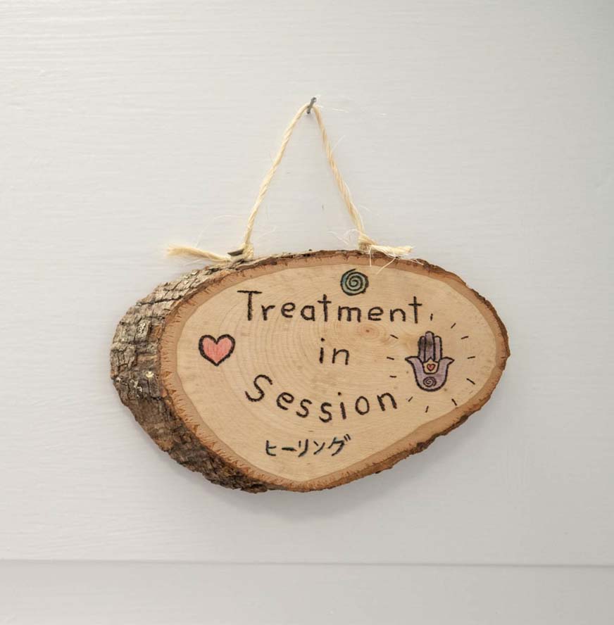A custom cut-log sign inside Placeres Integrative Medicine reads "Treatment in Session" with a small heart